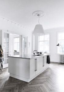 Grey wash Authentic herringbone laminate floor laid in a modern renovated kitchen