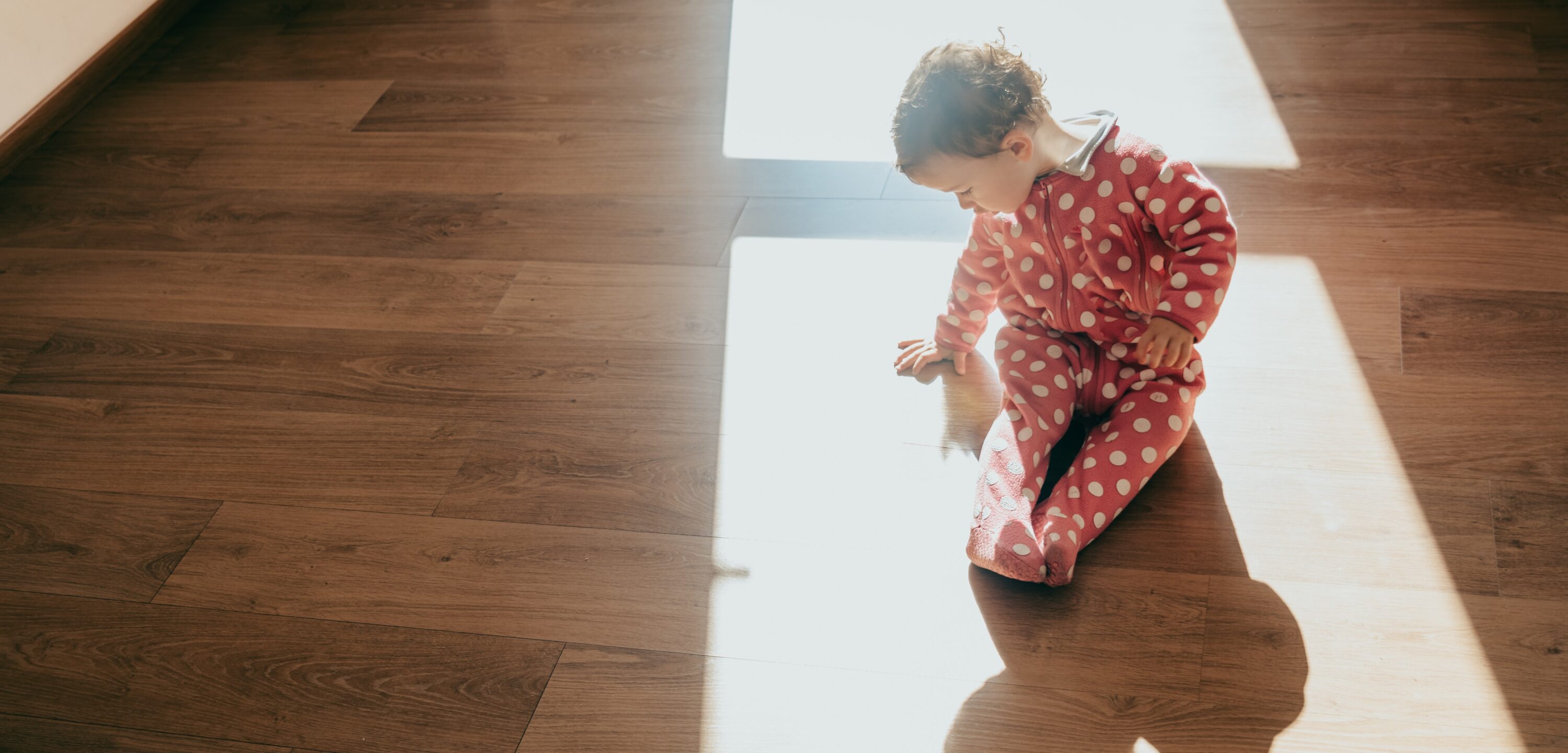 Baby on vinyl floor with sunlight